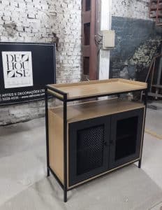 Mueble contemporáneo con marco metálico negro, puertas de malla negra y encimera de madera clara, ideal para almacenamiento y decoración moderna.